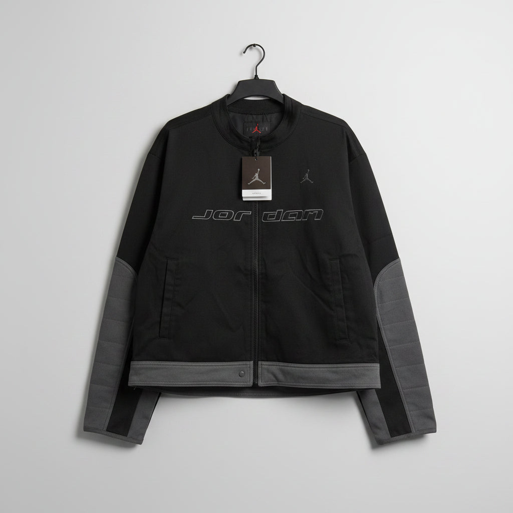 Black jacket with visible branding on a pegboard background